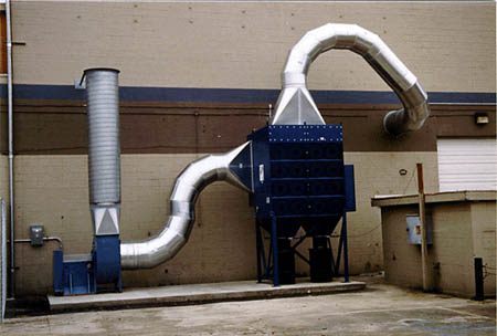 Image #152  4DF32 outdoors with inlet and outlet ductwork to remote-mounted fan, and 55-gallon drums